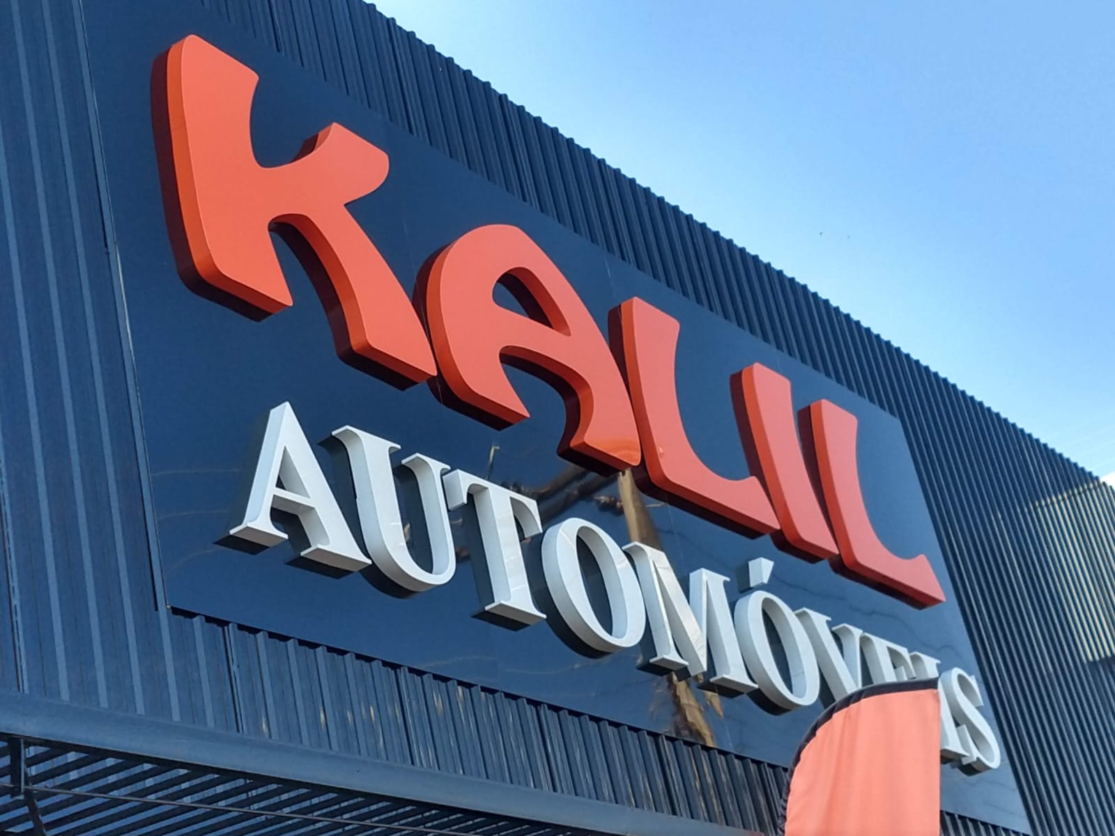 Placa personalizada com letras em relevo instalada em fachada comercial